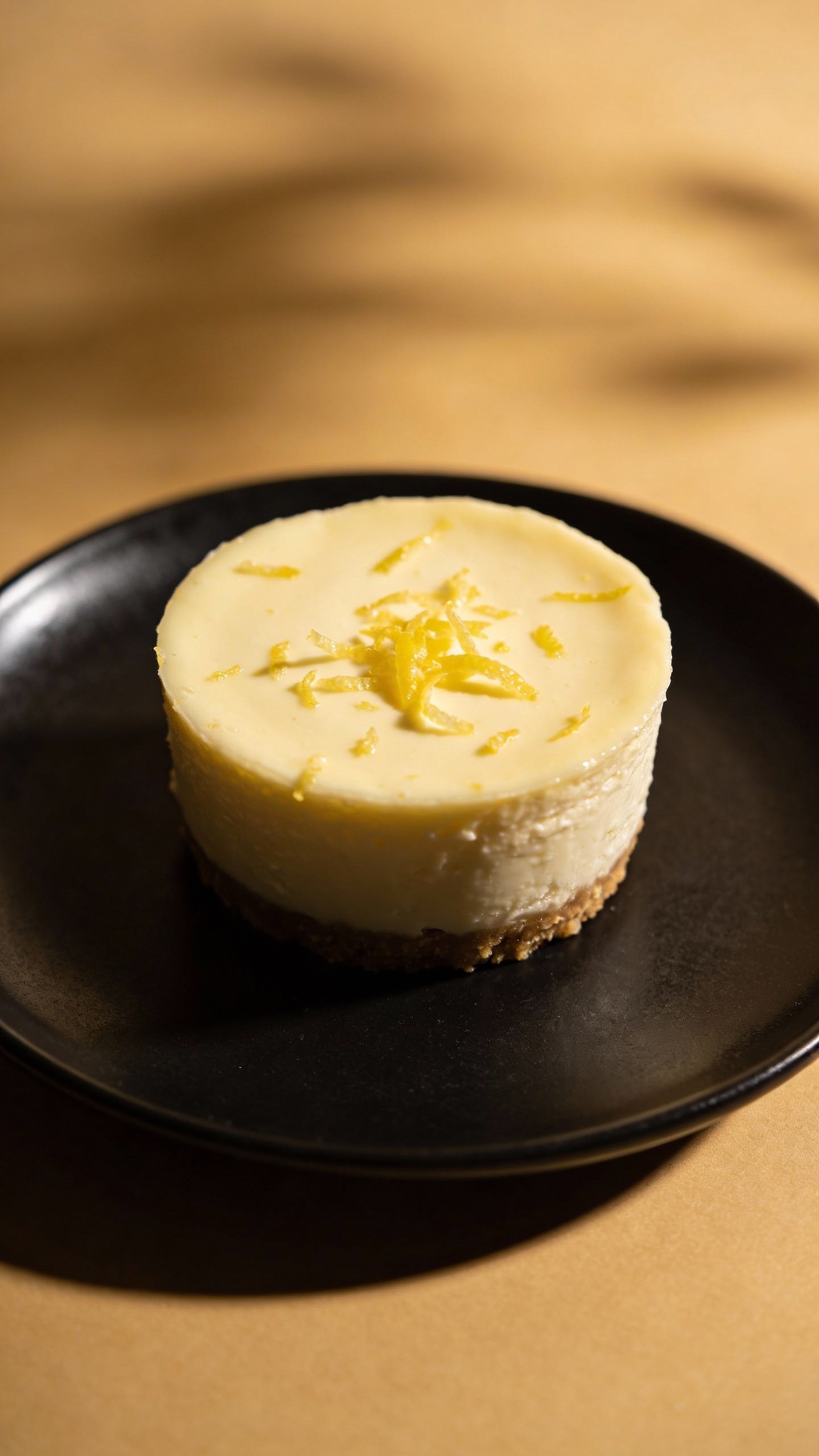 keto lemon cheesecake cup on matte black plate, studio light