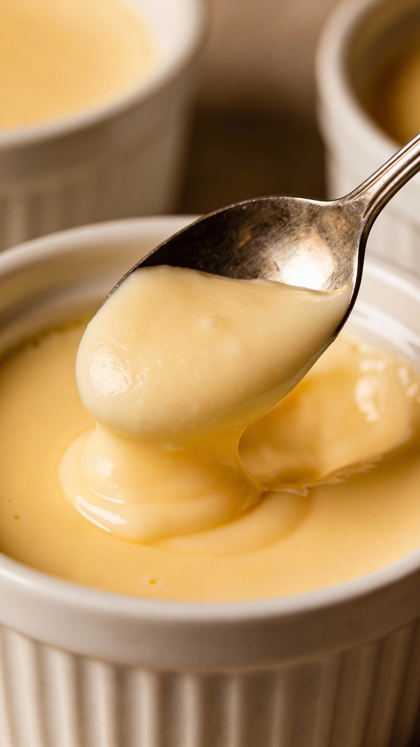 spoon scooping silky keto vanilla custard from ramekin