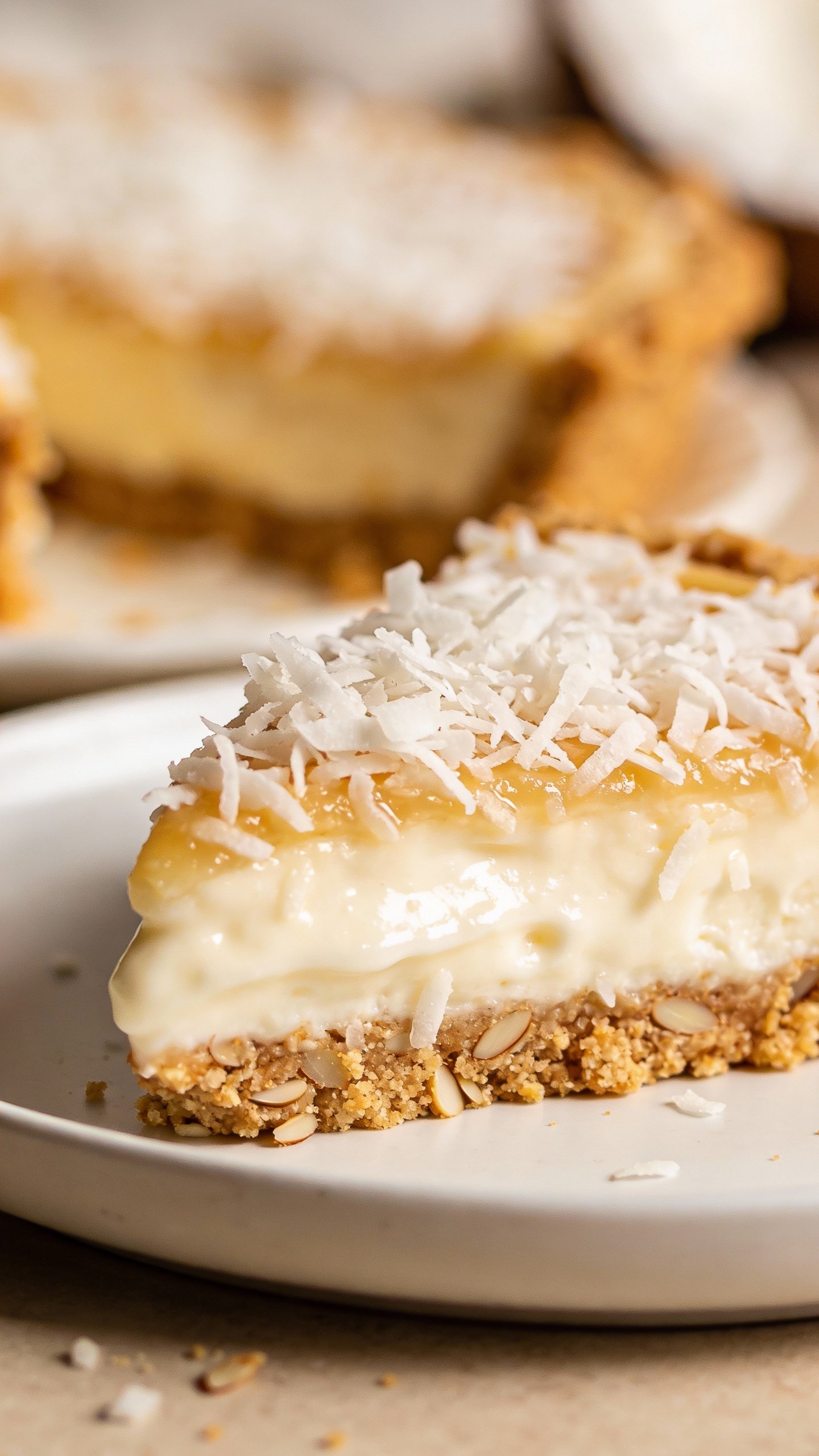 closeup keto coconut cream pie bar on white plate