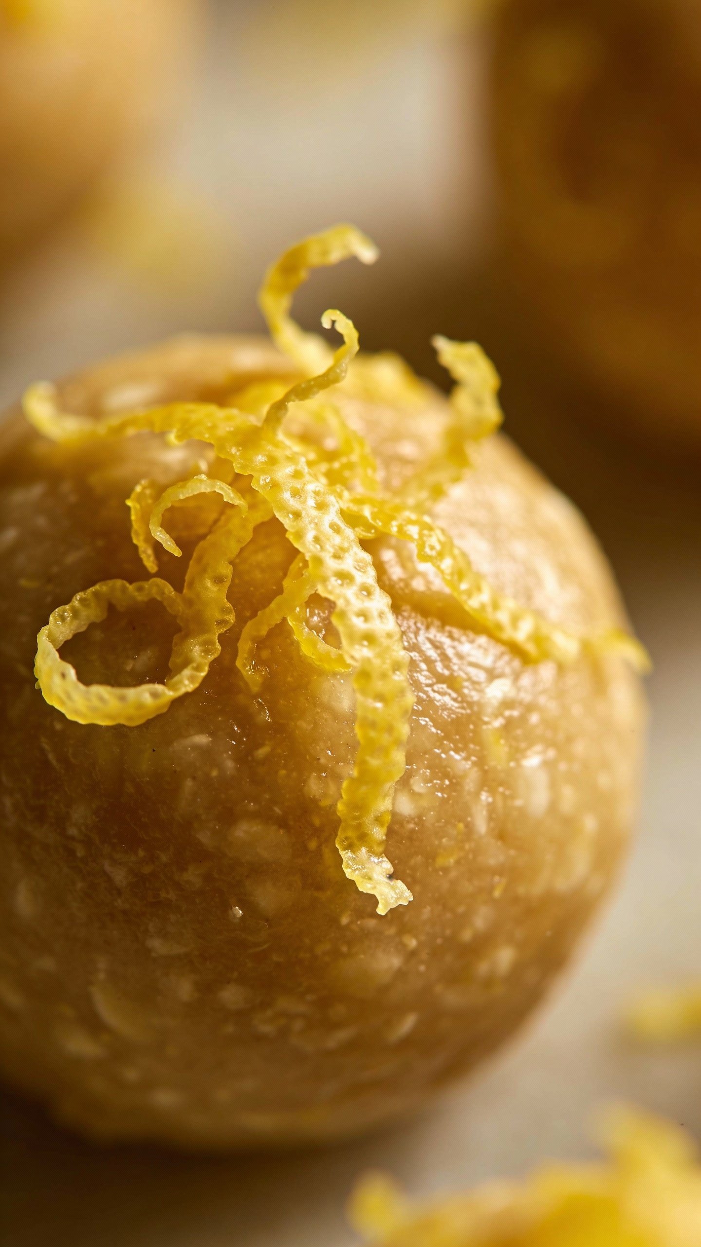 macro shot of lemon zest on a single bliss ball