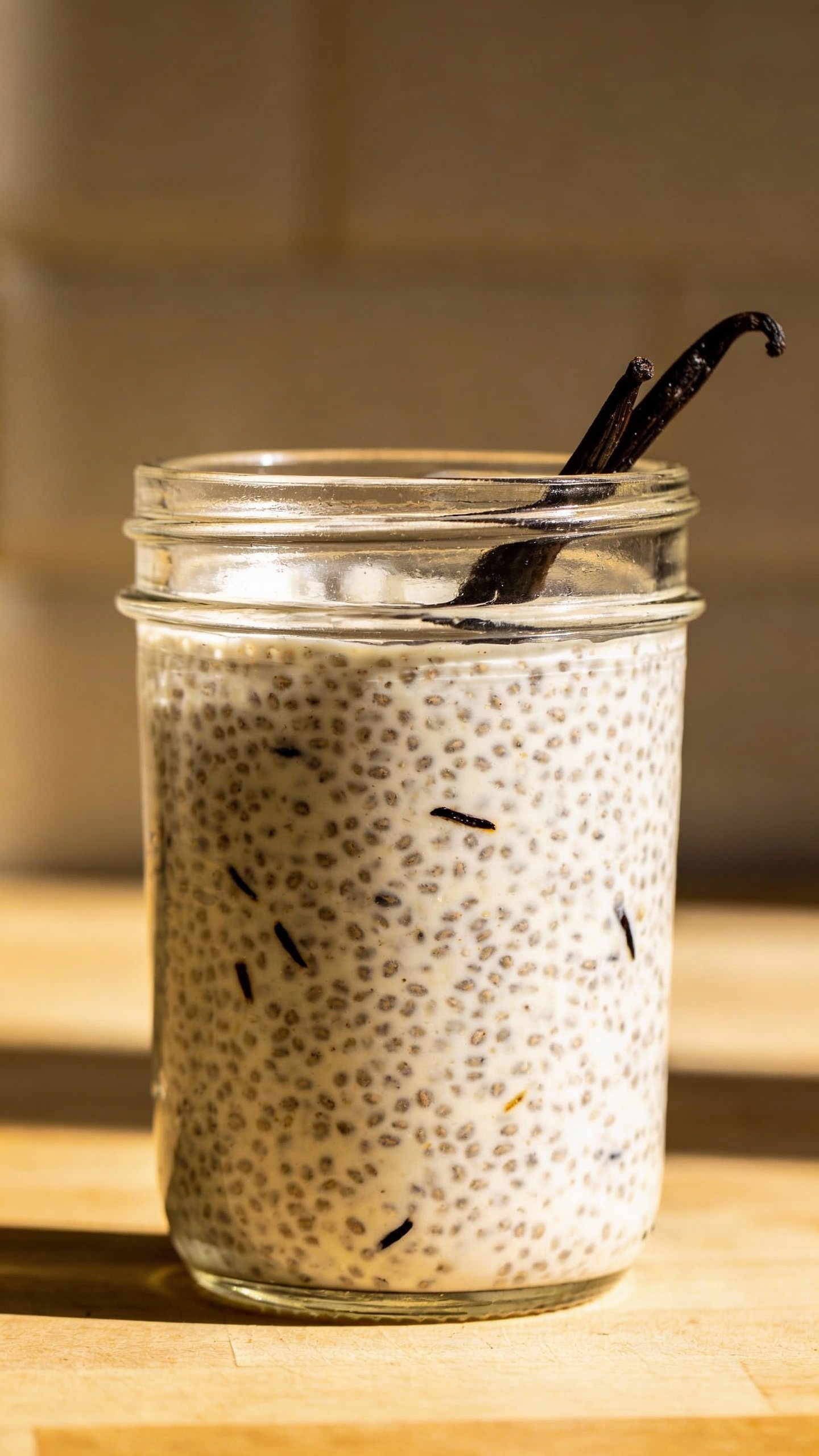 single mason jar of chia pudding with vanilla bean flecks