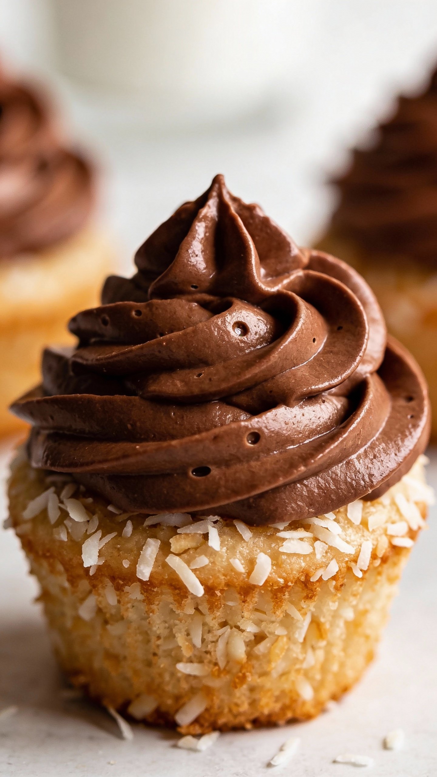 closeup swirl of keto chocolate buttercream on coconut cupcake
