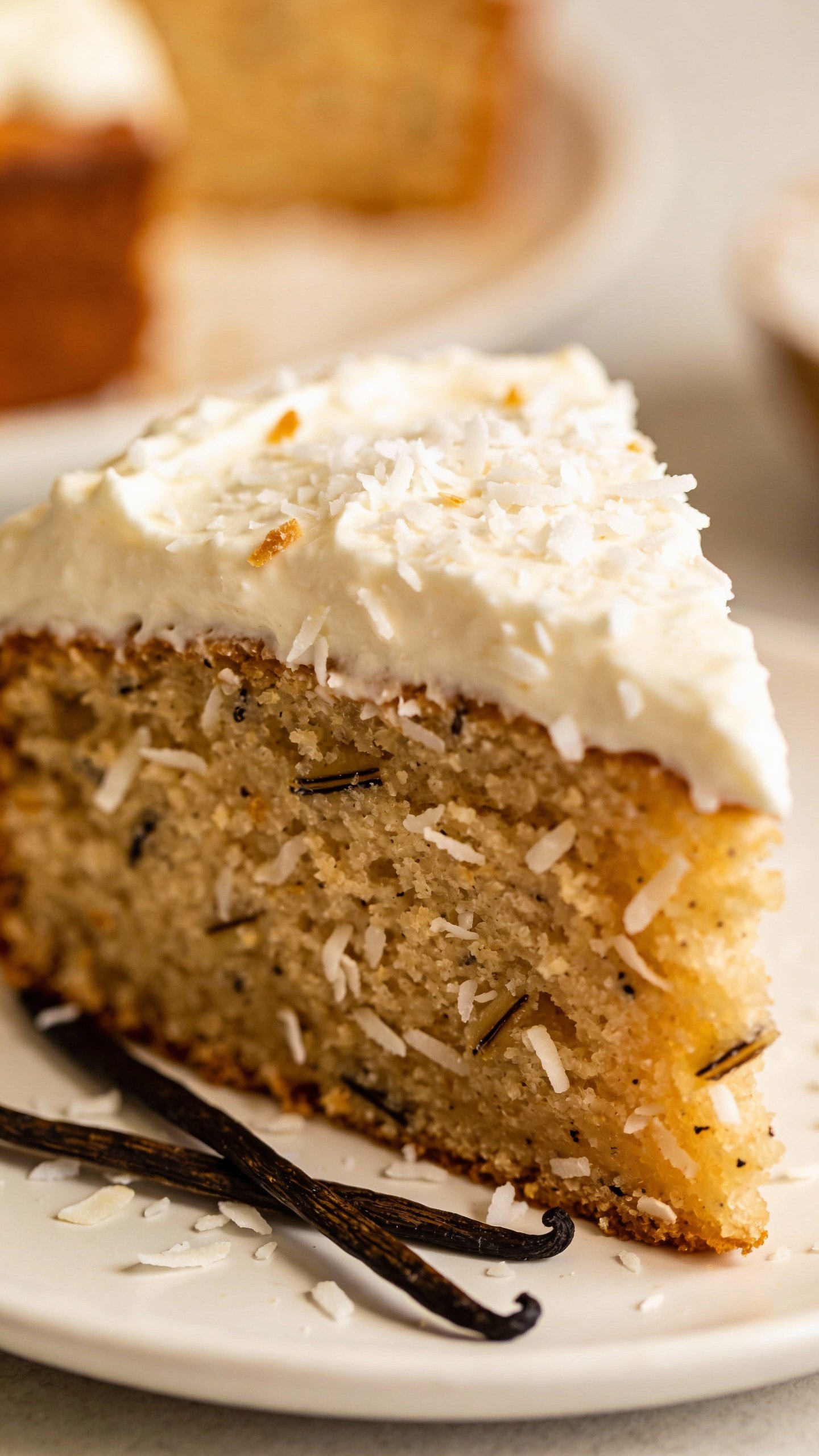 closeup slice of keto vanilla coconut cake on white plate