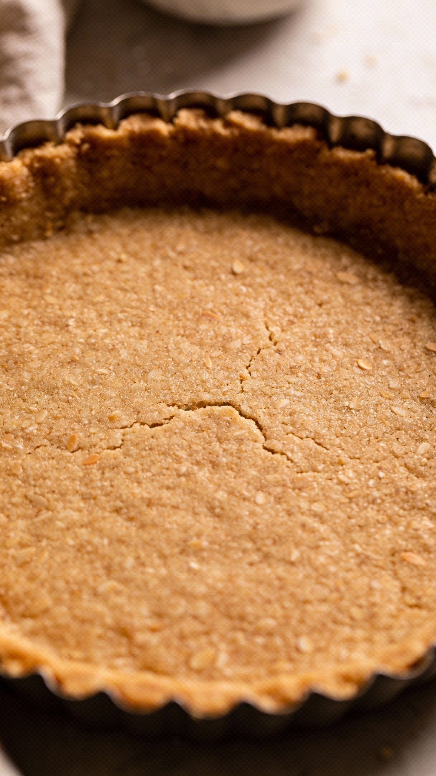 overhead almond flour tart crust in fluted tin, golden-brown