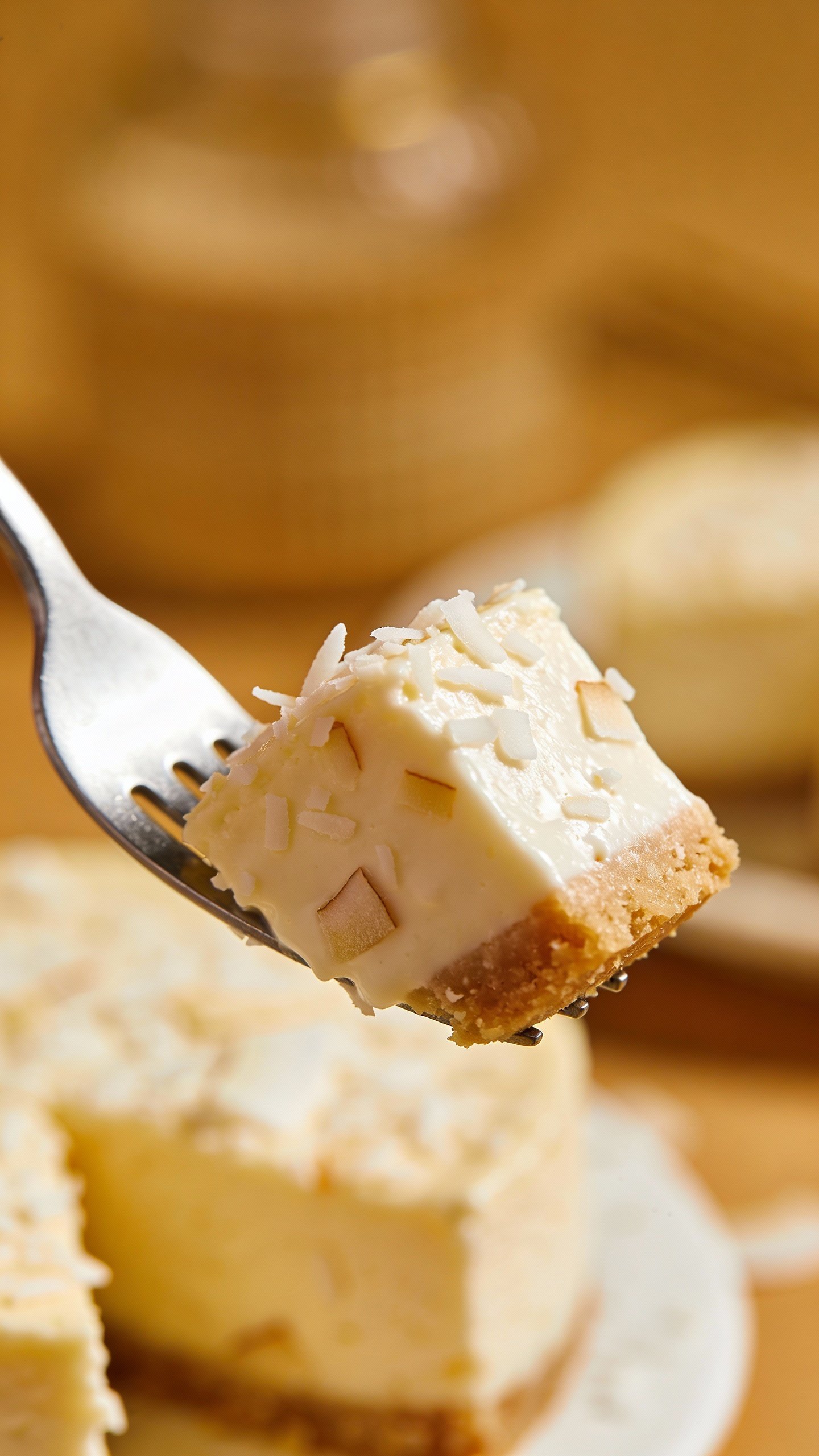 creamy vanilla coconut cheesecake bite on silver fork