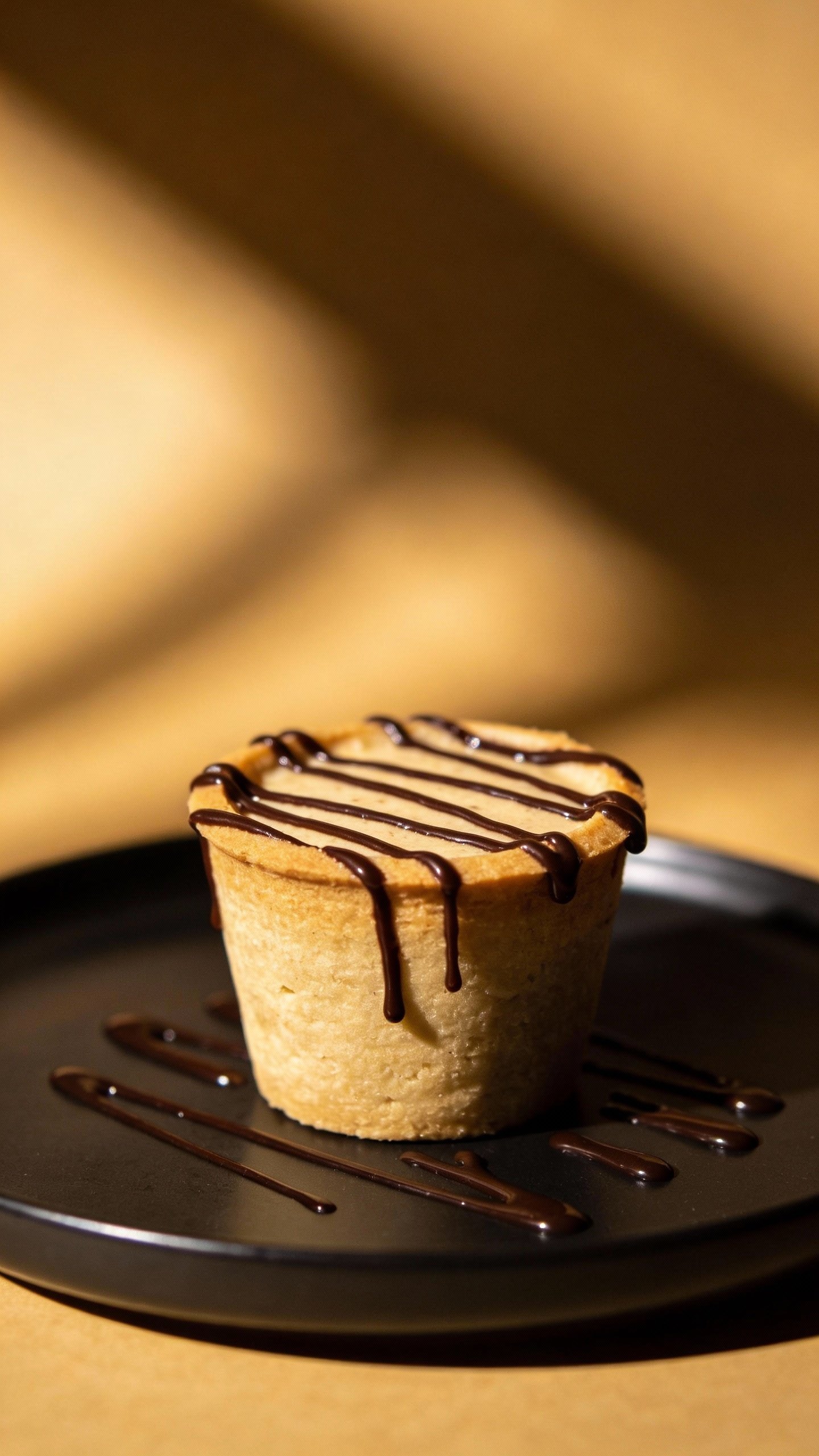 drizzled dark chocolate keto cup on matte black plate