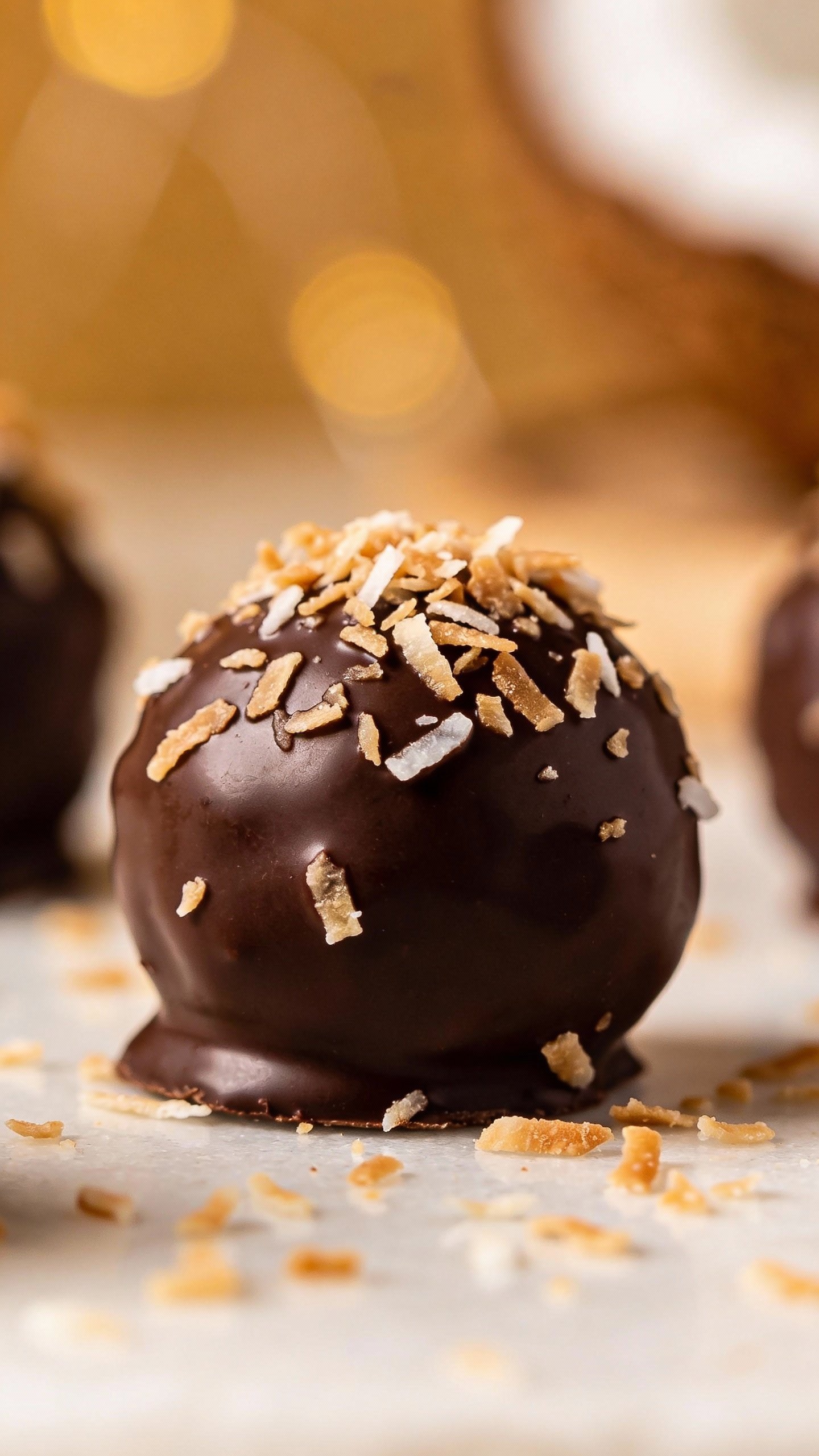 single coconut chocolate fat bomb with flaked coconut topping