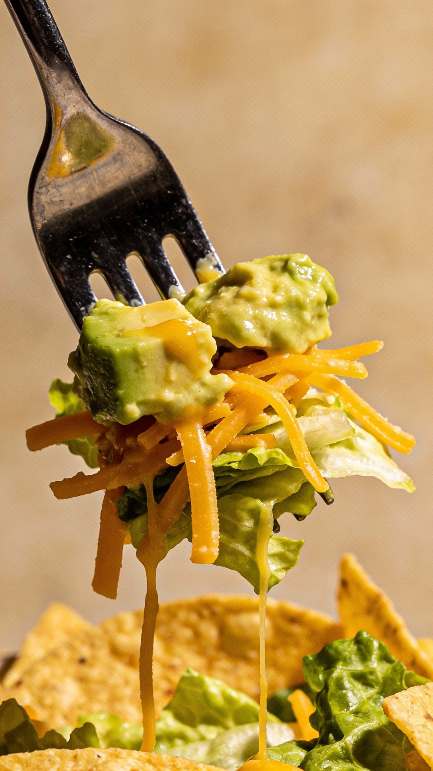 forkful of avocado, cheddar, and lettuce from taco salad