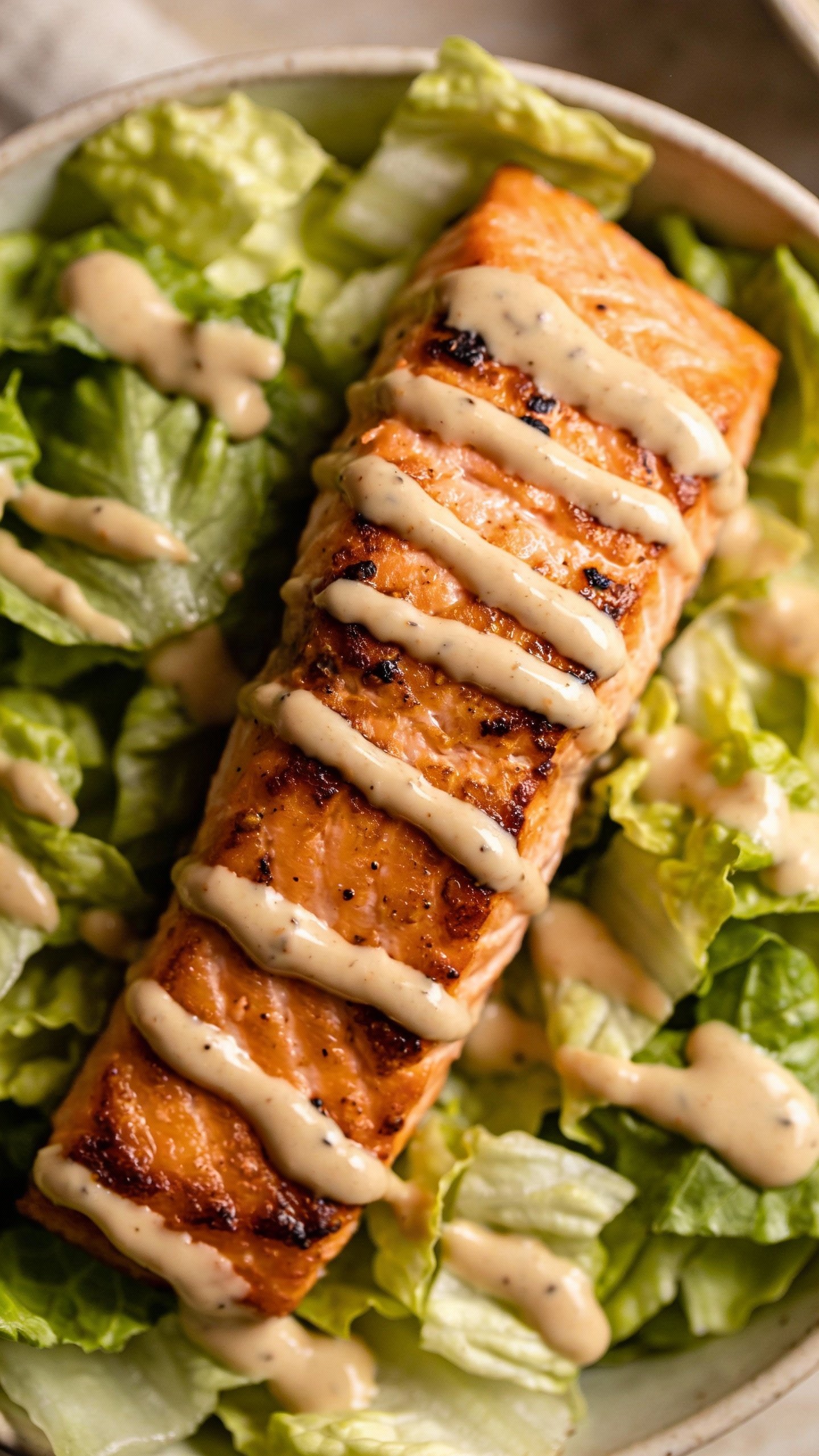 overhead shot of seared salmon keto bowl with romaine and tahini