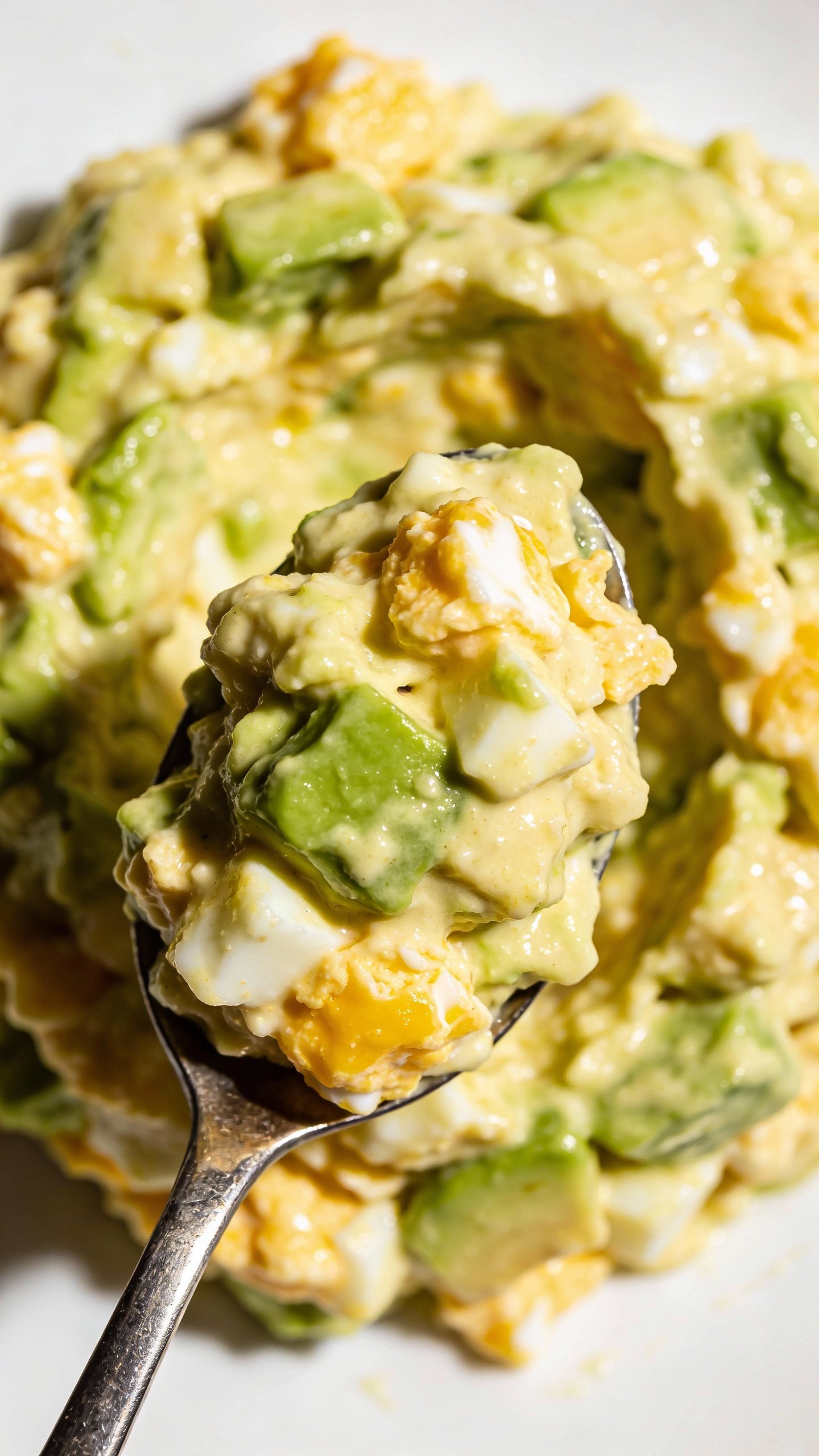 spoonful of creamy avocado egg salad, overhead macro