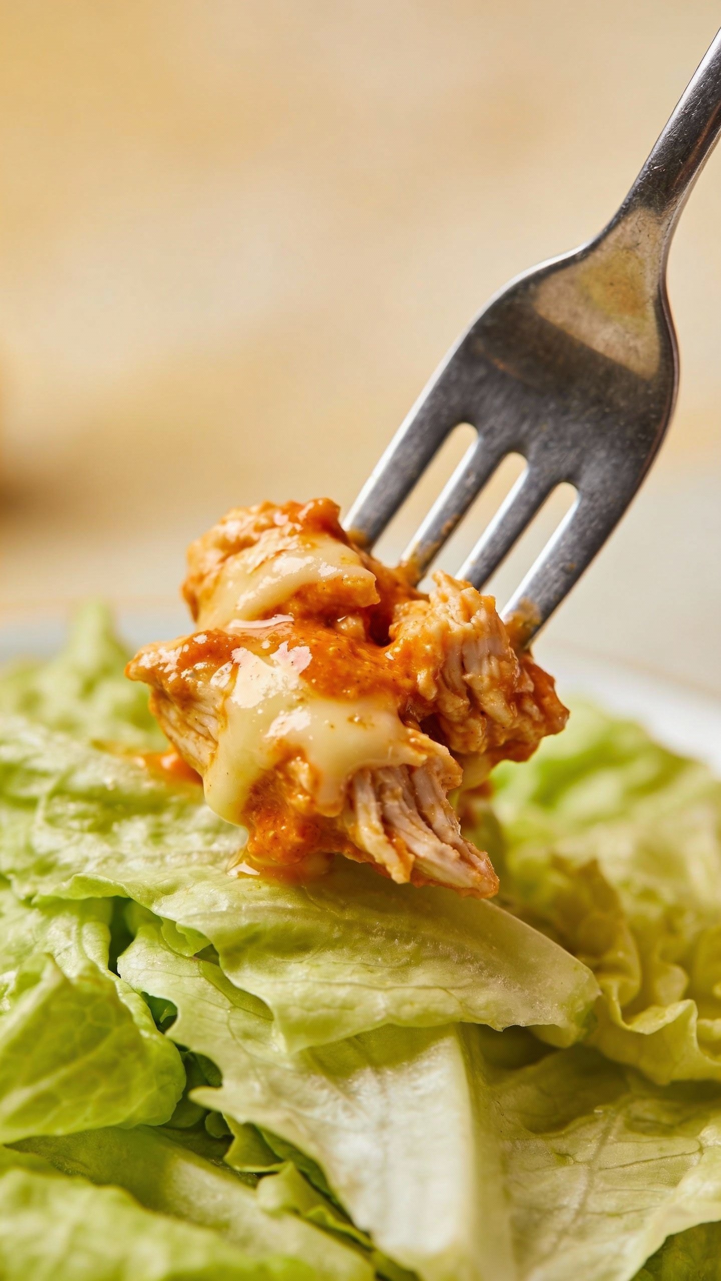 single forkful of cheesy buffalo chicken over romaine, shallow depth