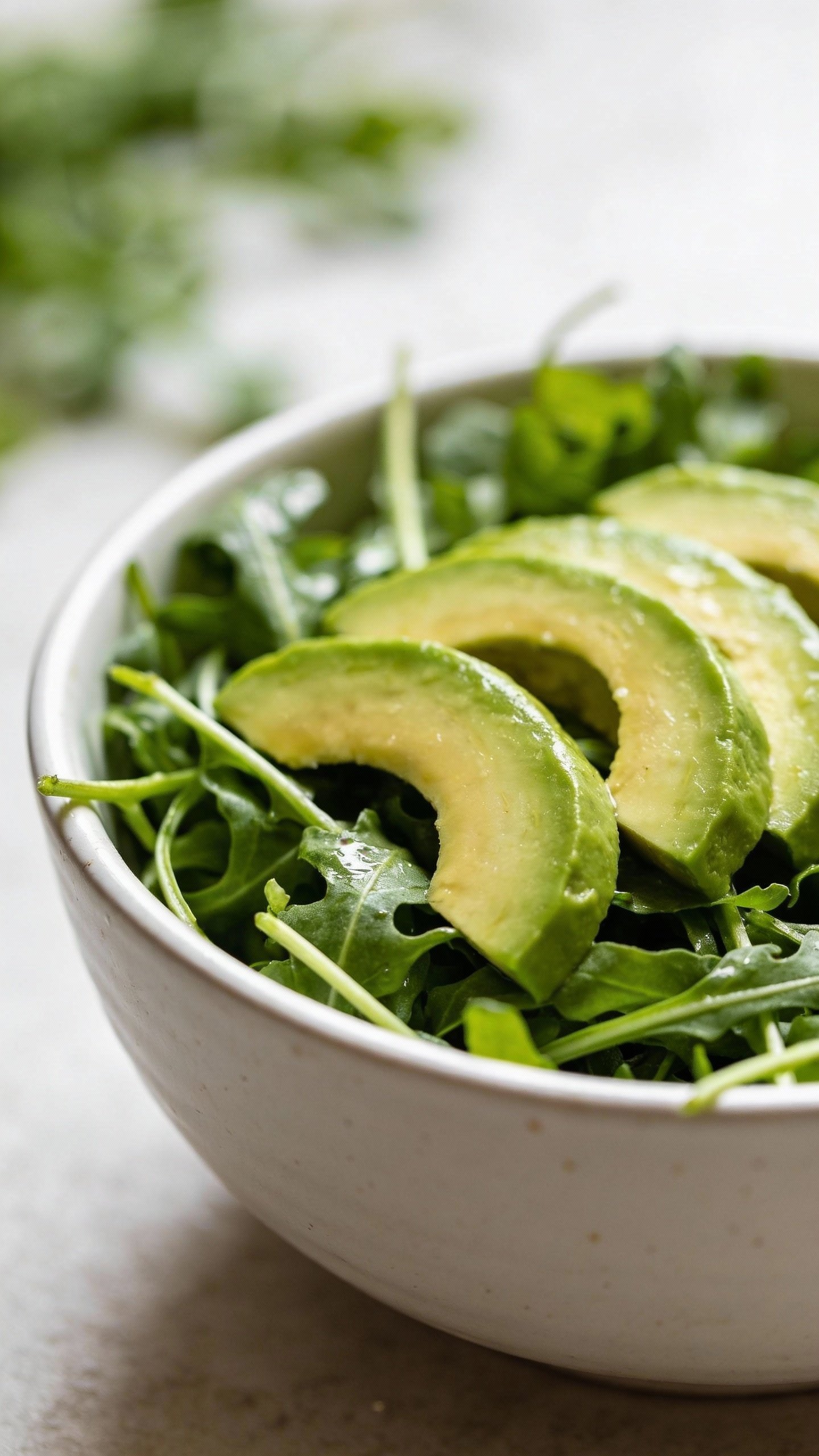 closeup bowl of spring mix keto salad with avocado slices