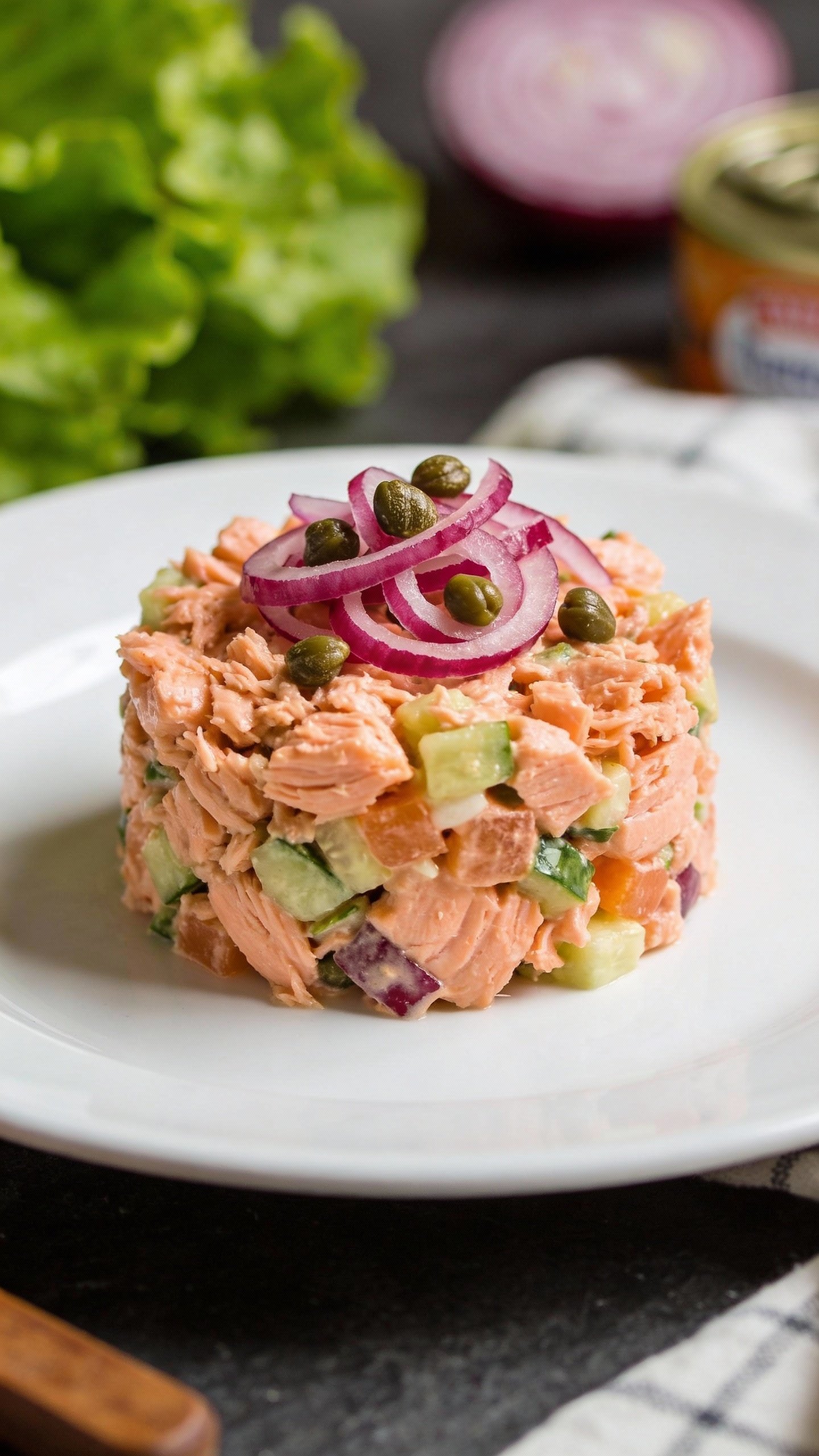 canned salmon salad mound on white plate, tangy garnish