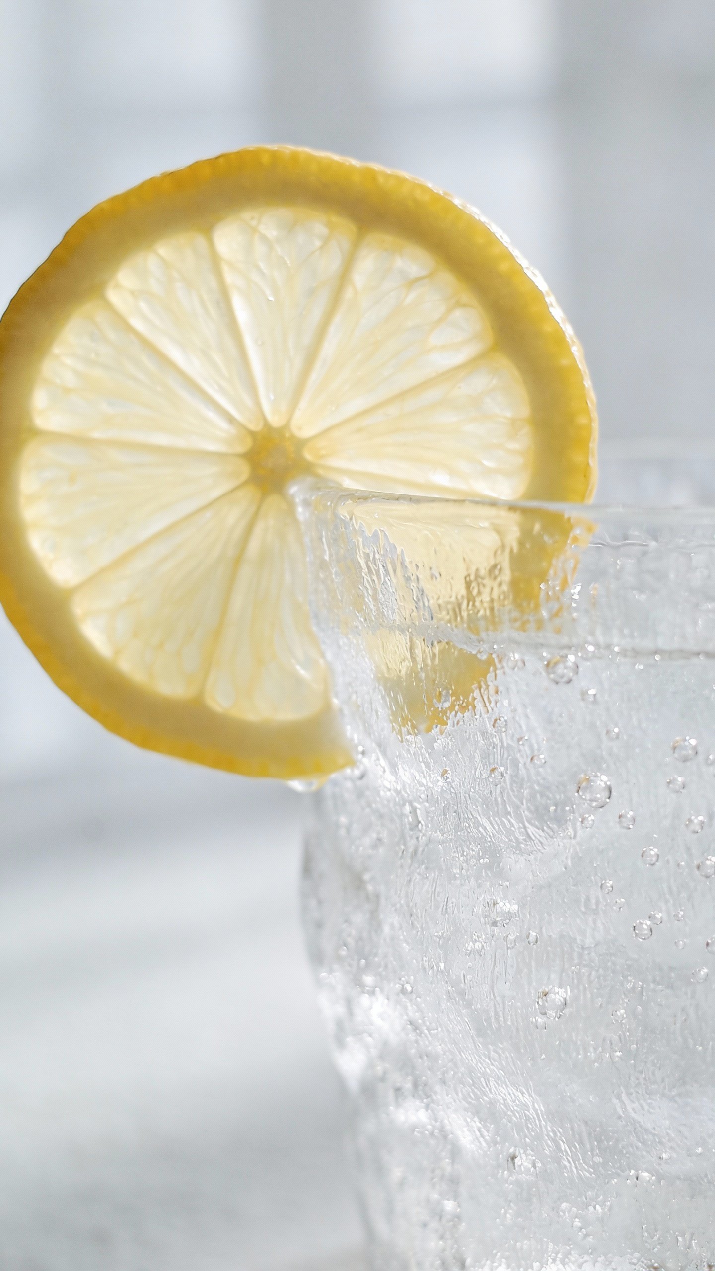 lemon slice on rim of frosted glass, condensation beads