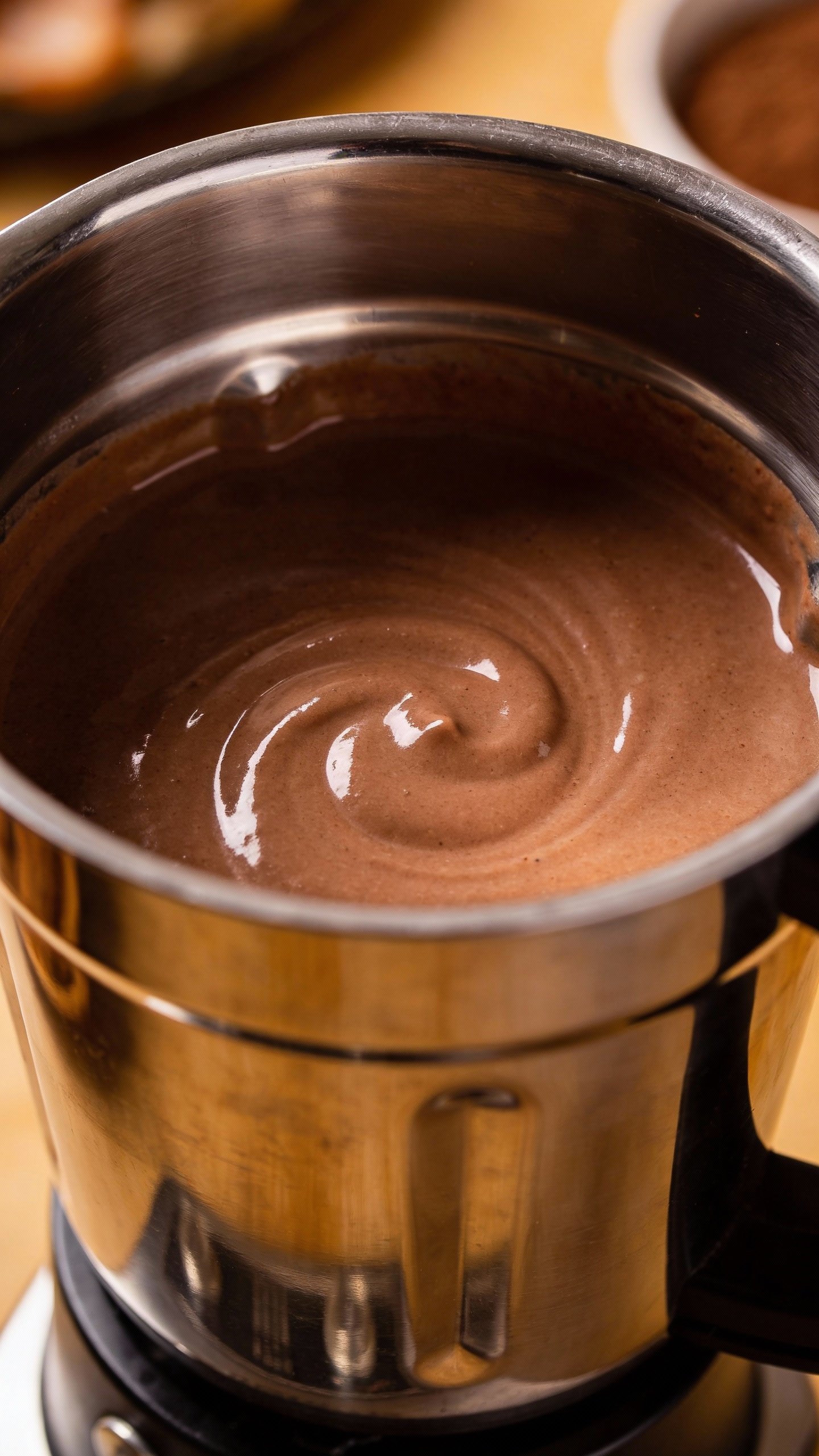 stainless blender cup with chocolate smoothie, creamy texture detail