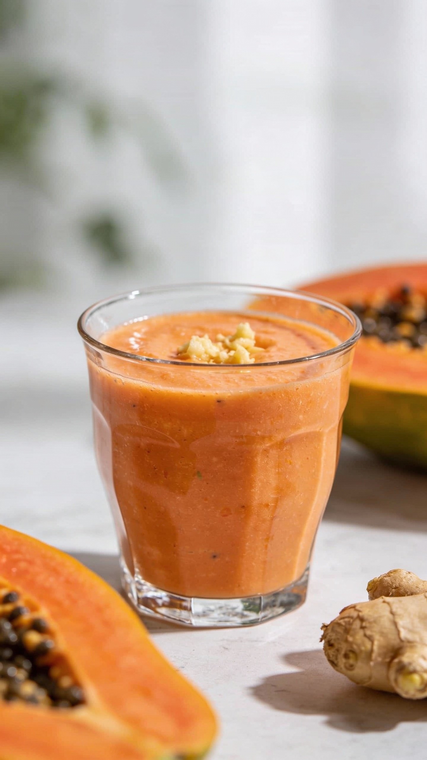 closeup papaya ginger smoothie in clear glass, soft daylight