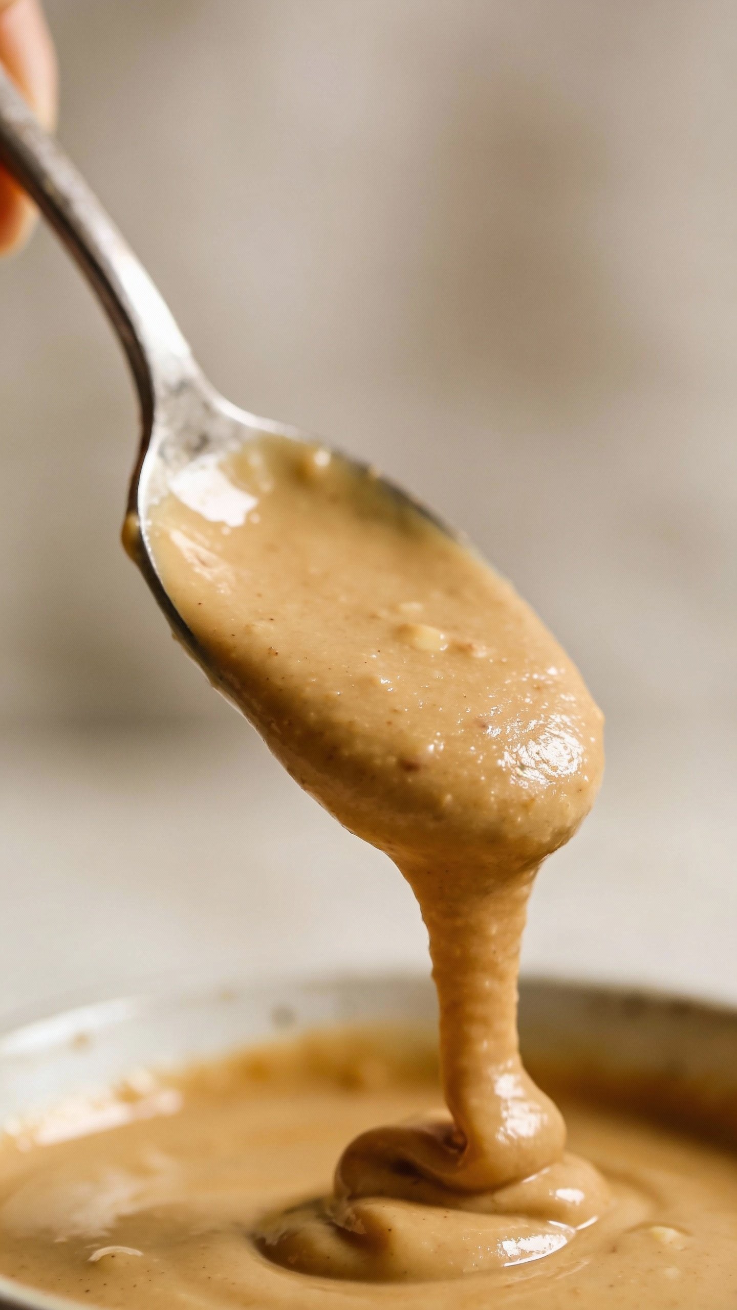 spoonful of creamy almond butter over neutral backdrop