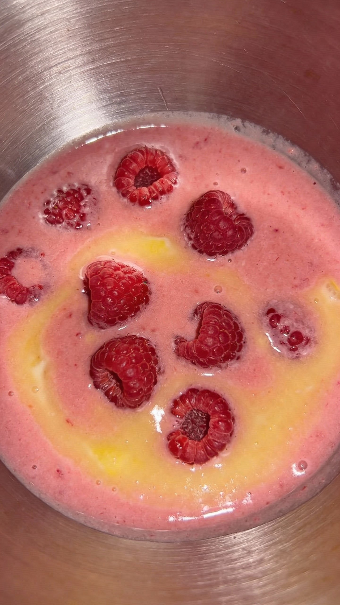 stainless blender jar with raspberry lemon puree, top-down closeup