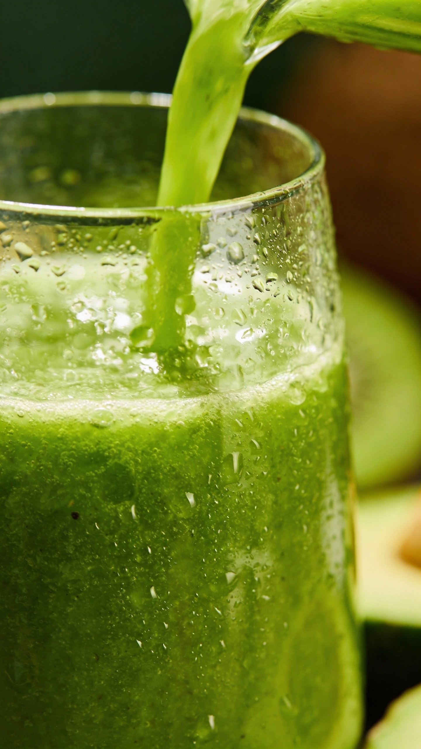 closeup tropical green detox smoothie in clear glass, condensation