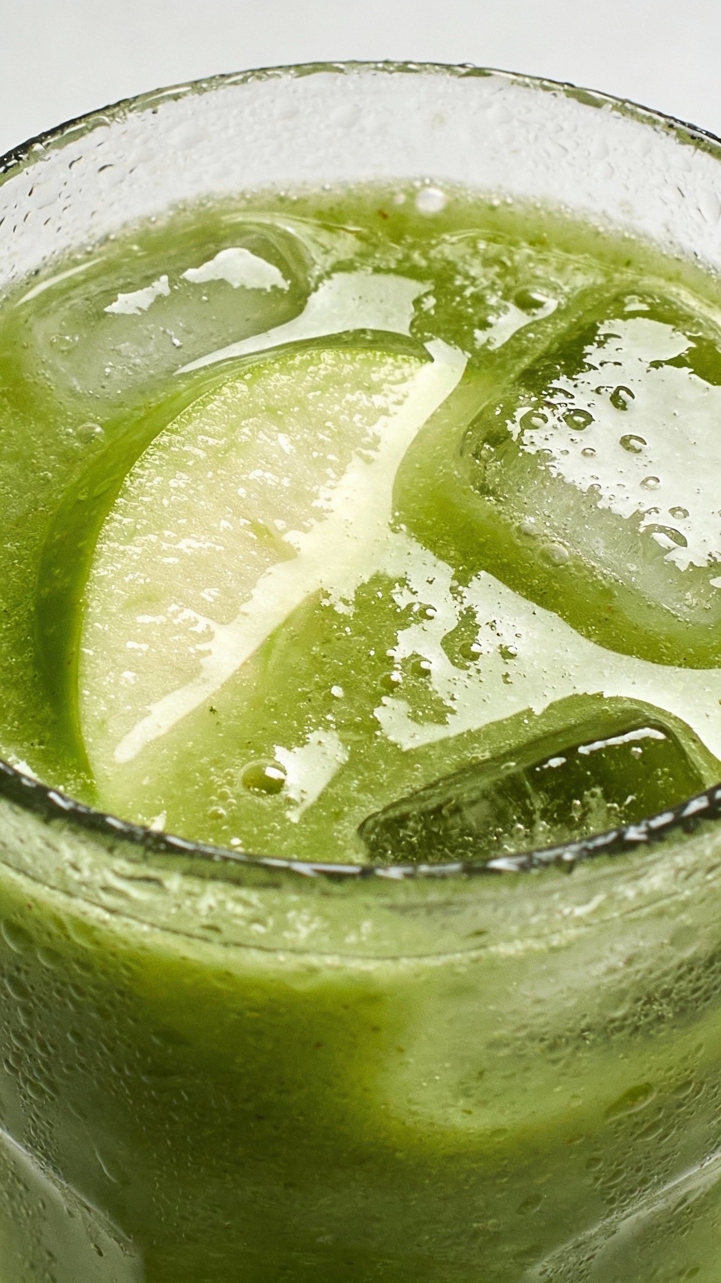 closeup glass of green apple detox smoothie, condensation, studio light