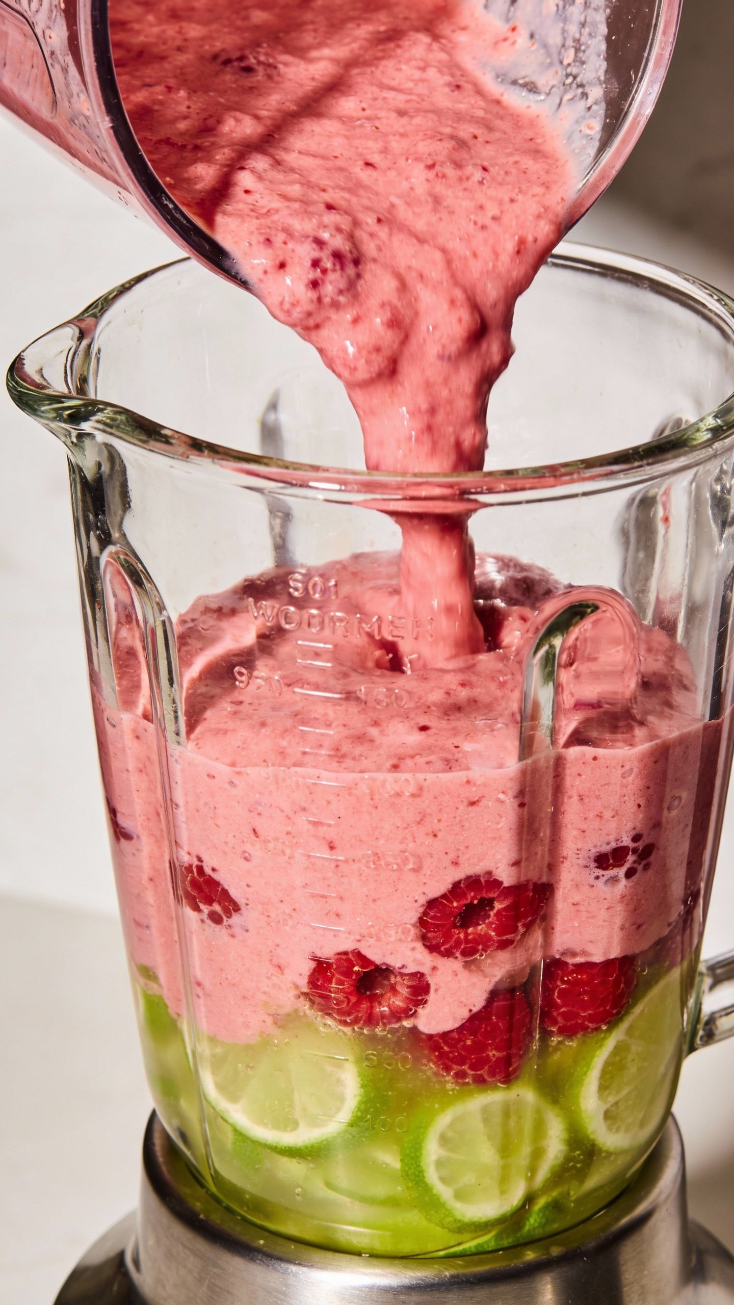 Stainless blender jar filled with raspberry-lime puree, closeup