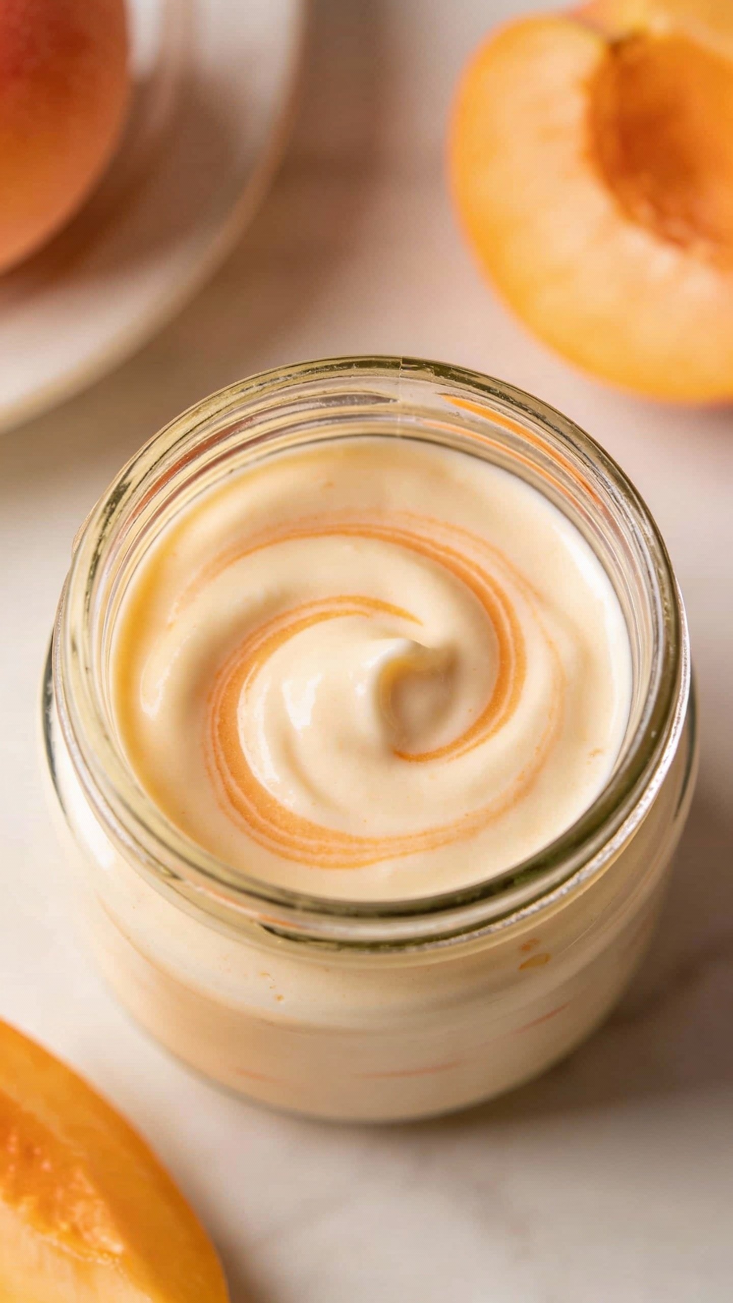 creamy peach yogurt swirl in small glass jar, overhead shot