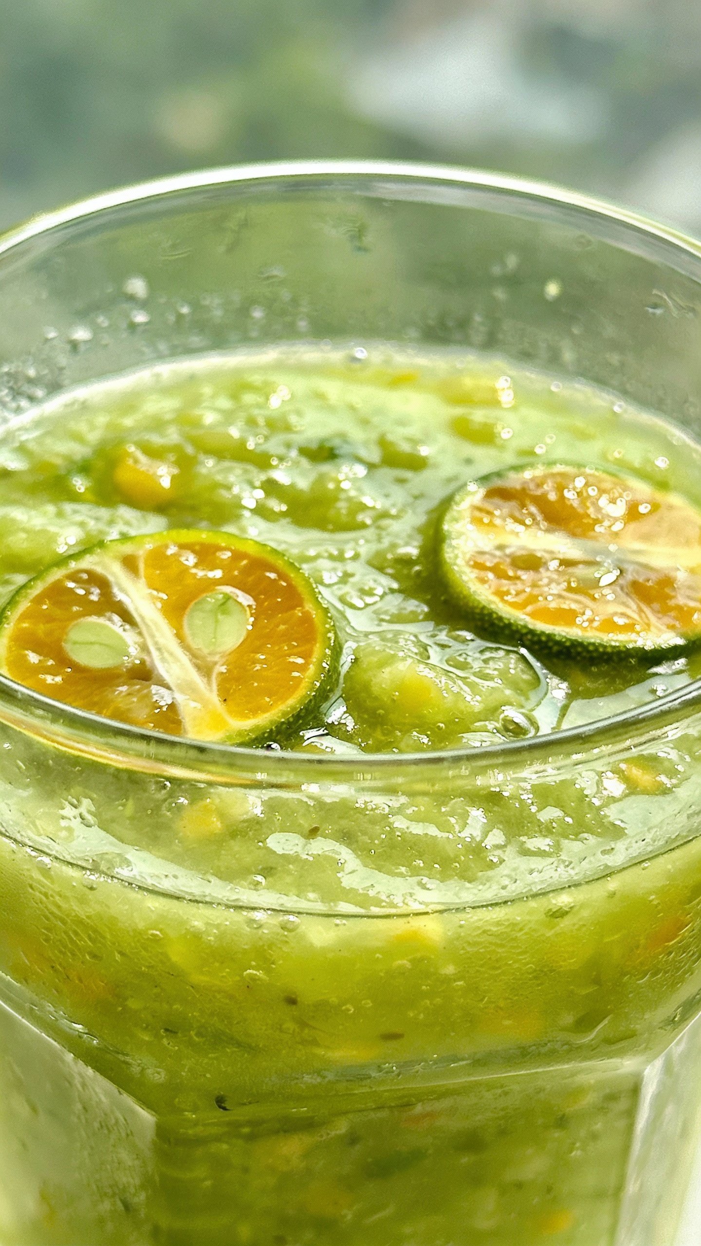 closeup tropical citrus green smoothie in clear glass