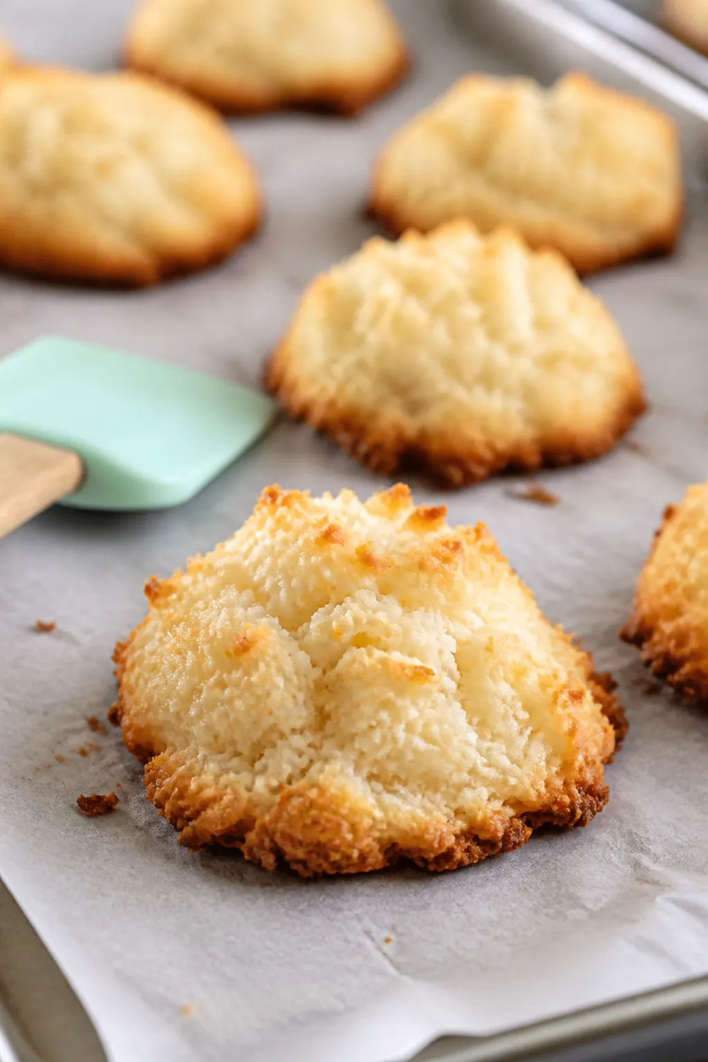 Close-up detail, cooking process: Golden-edged low-carb lemon coconut macaroons just out of the oven