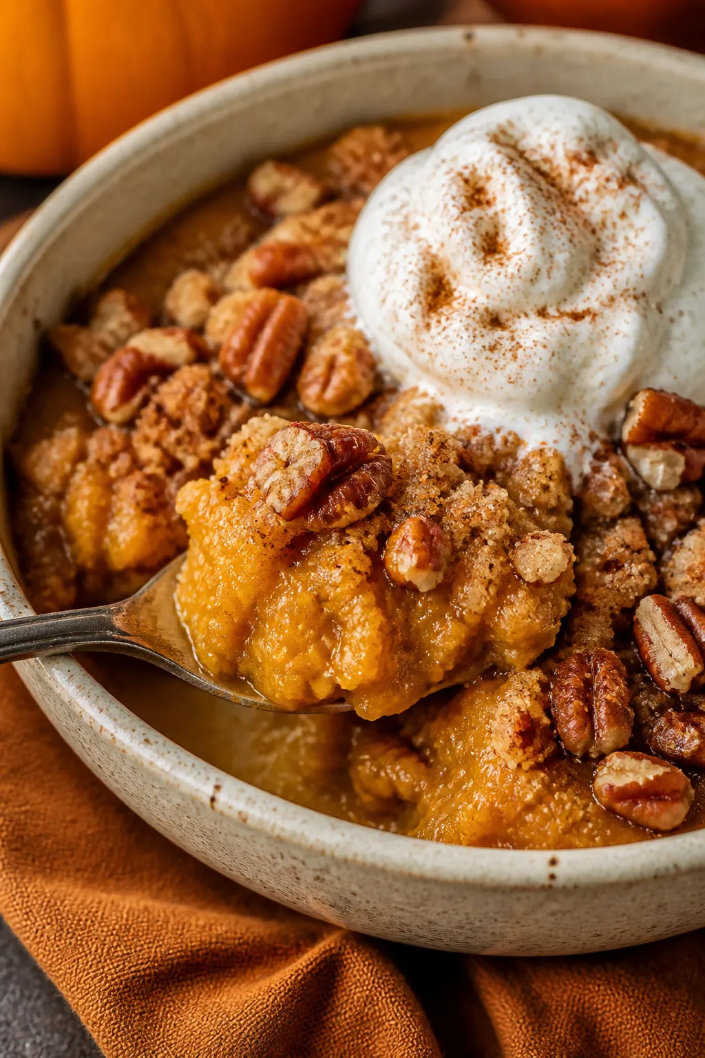 Close-up detail of a served spoonful of Keto Pumpkin Cobbler in a rustic ceramic bowl, showcasing th