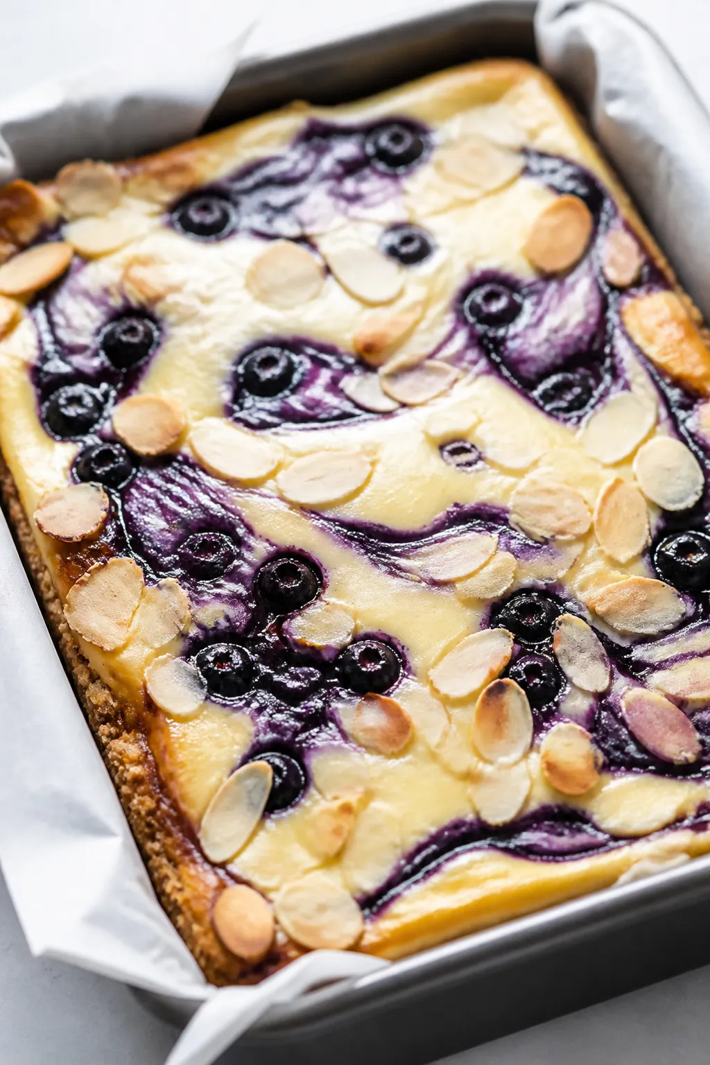 Close-up detail of freshly baked Low Carb Blueberry Almond Cheesecake Bars just out of the oven in a