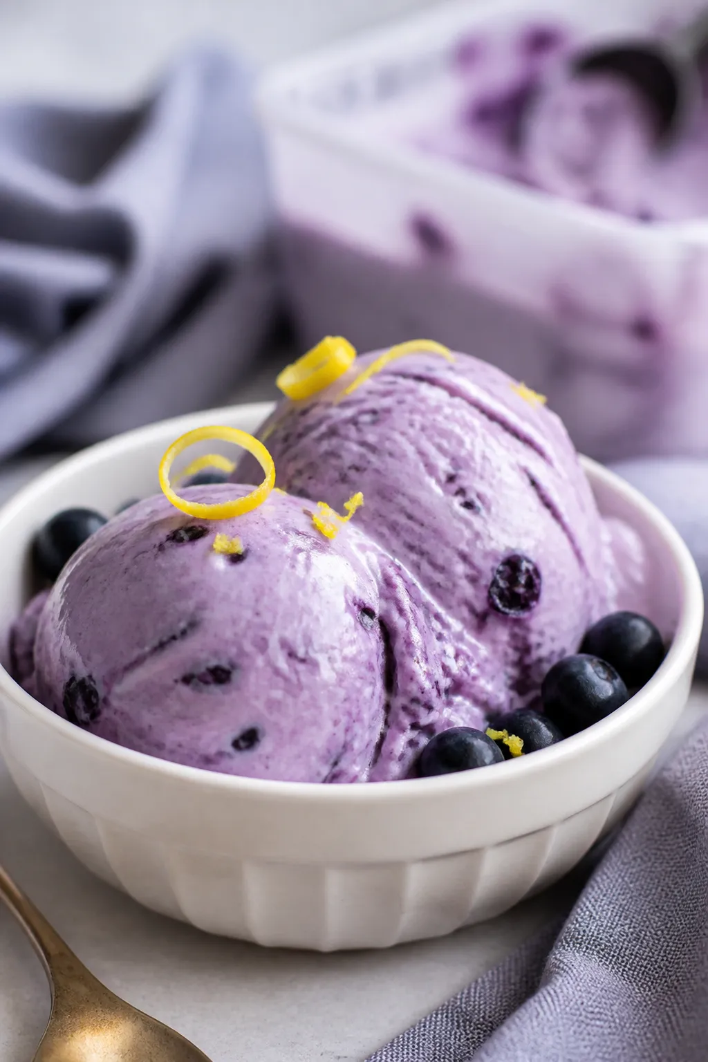 Close-up detail shot of a freshly scooped Low Carb Blueberry Cottage Cheese Ice Cream, two rounded s