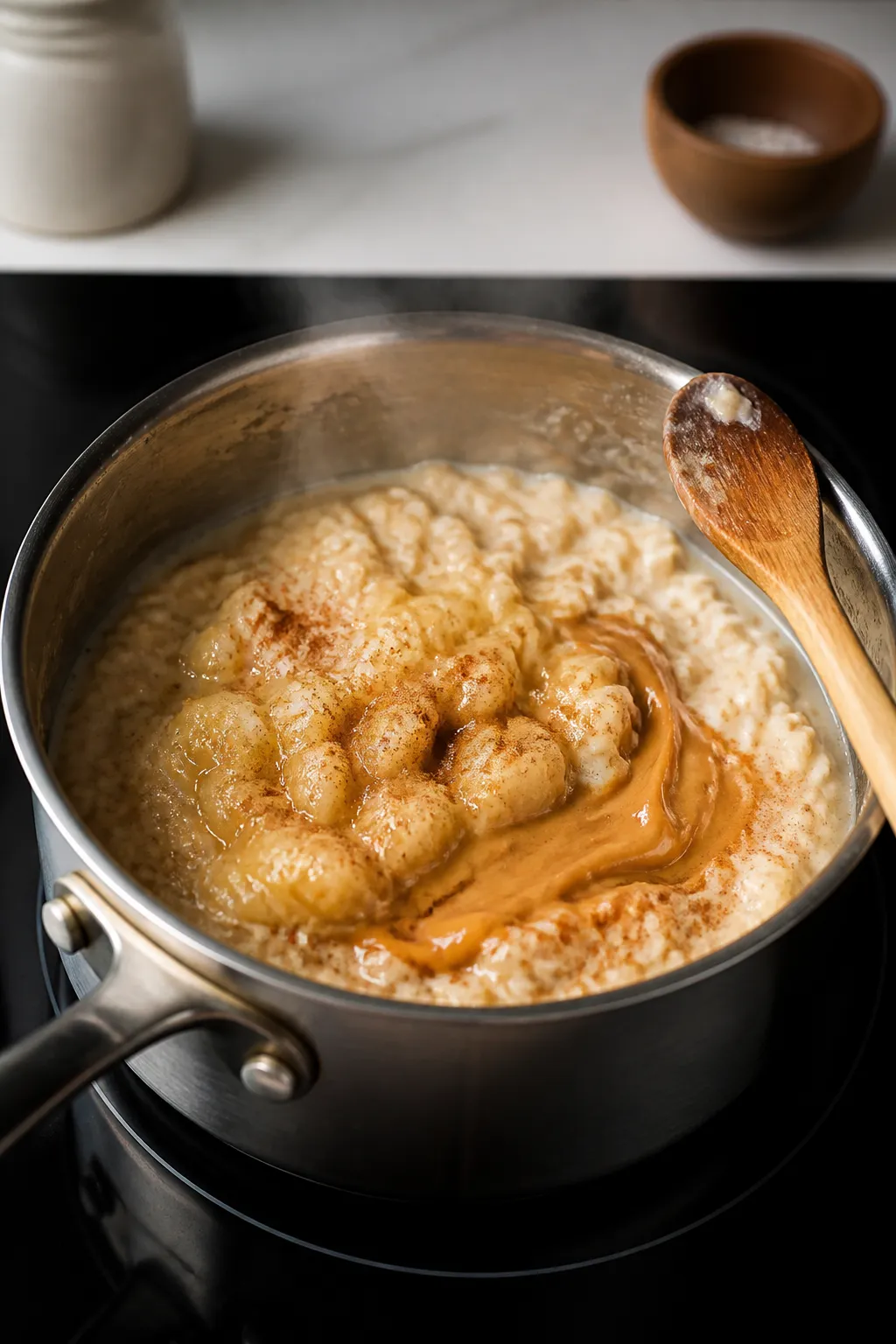 Cooking process close-up: A small saucepan on the stove with creamy rolled oats gently simmering in