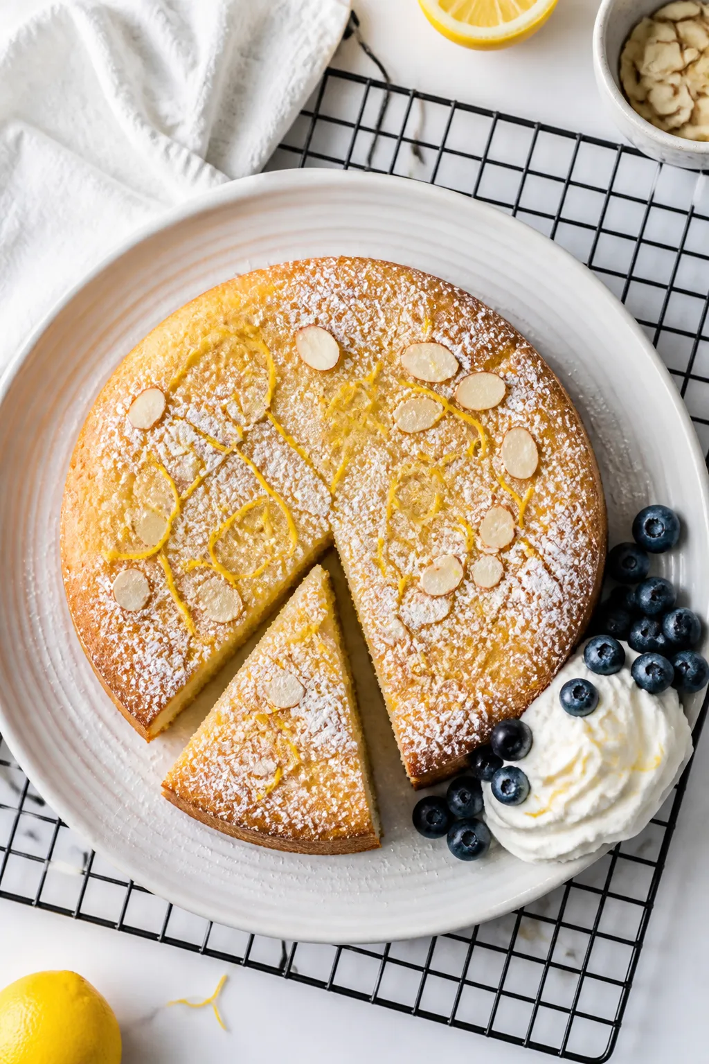 Final dish, tasty top view: Overhead shot of a fully baked Low Carb Lemon Ricotta Cake on a cooling 