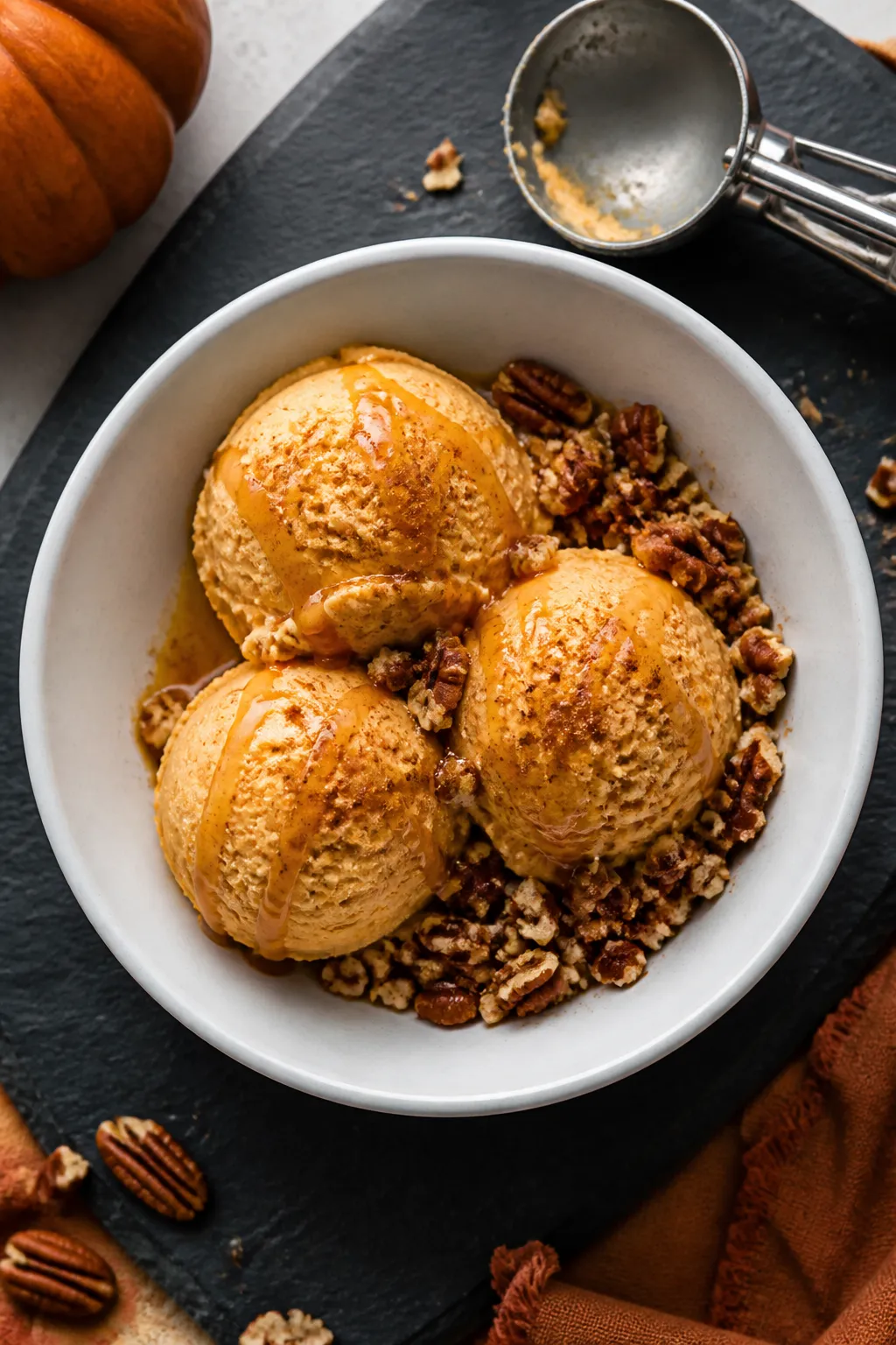 Final dish, tasty top view: Overhead shot of Keto Pumpkin Pie Ice Cream scooped into a chilled matte