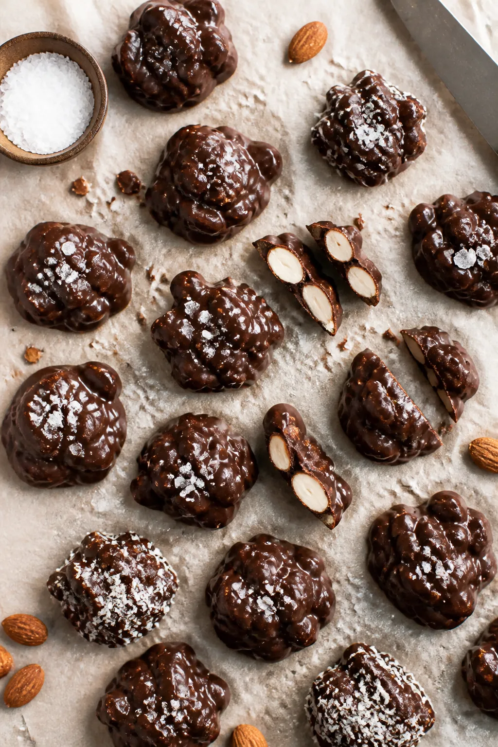 Final dish top view: Overhead shot of keto chocolate almond clusters neatly arranged on parchment, e