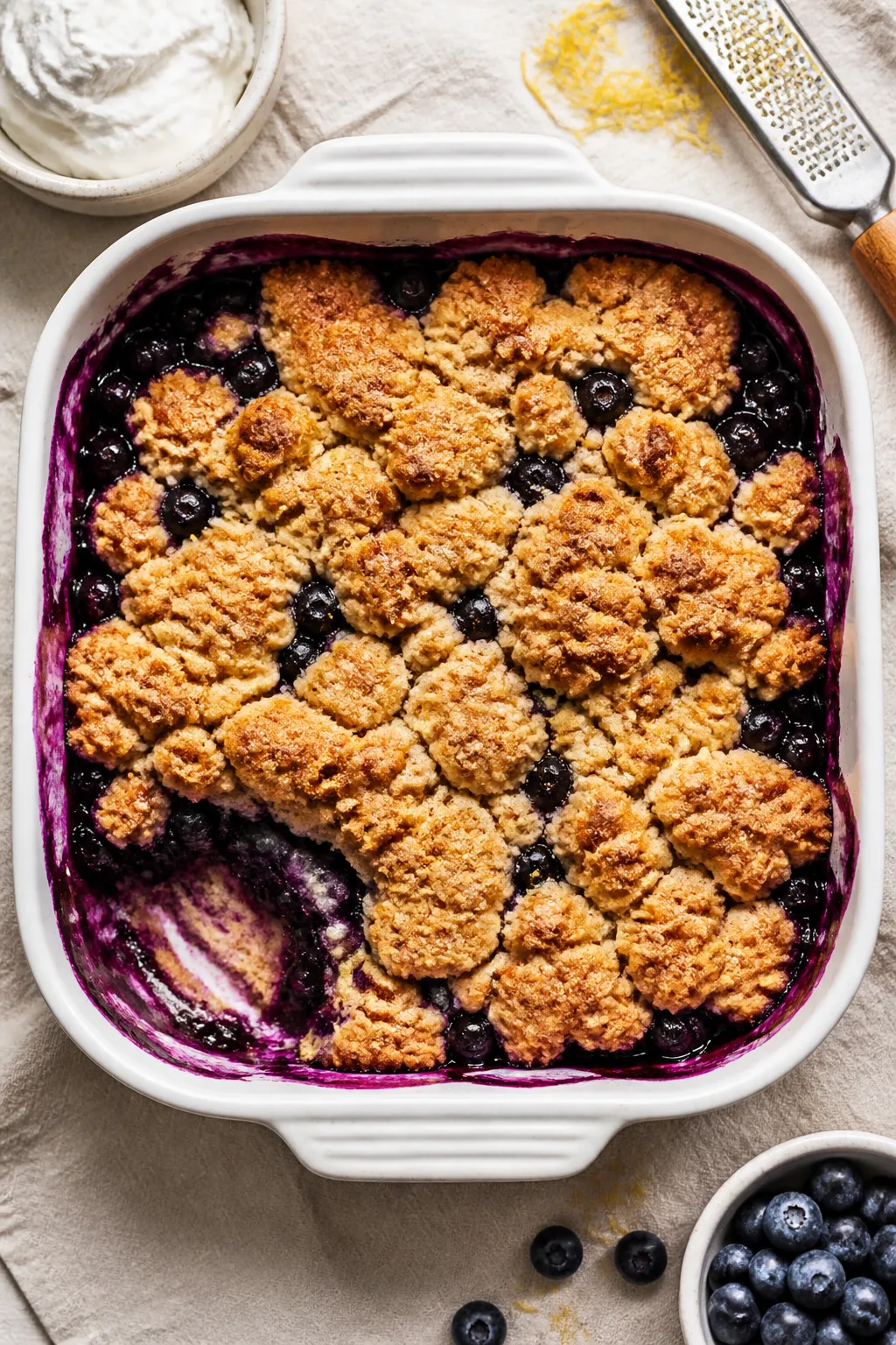 Overhead shot of a freshly baked Low Carb Blueberry Cobbler just out of the oven in an 8x8 ceramic b