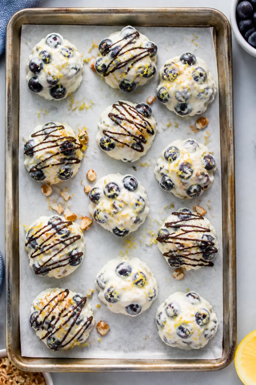 Overhead shot of finished low-carb blueberry frozen yogurt clusters arranged on a parchment-lined ba