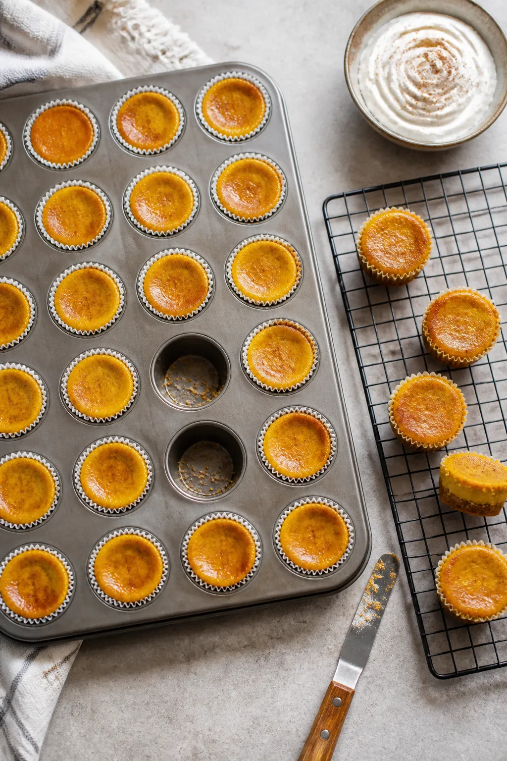 Overhead shot of freshly baked Keto Pumpkin Pie Cheesecake Bites cooling in a 24-cup mini muffin tin